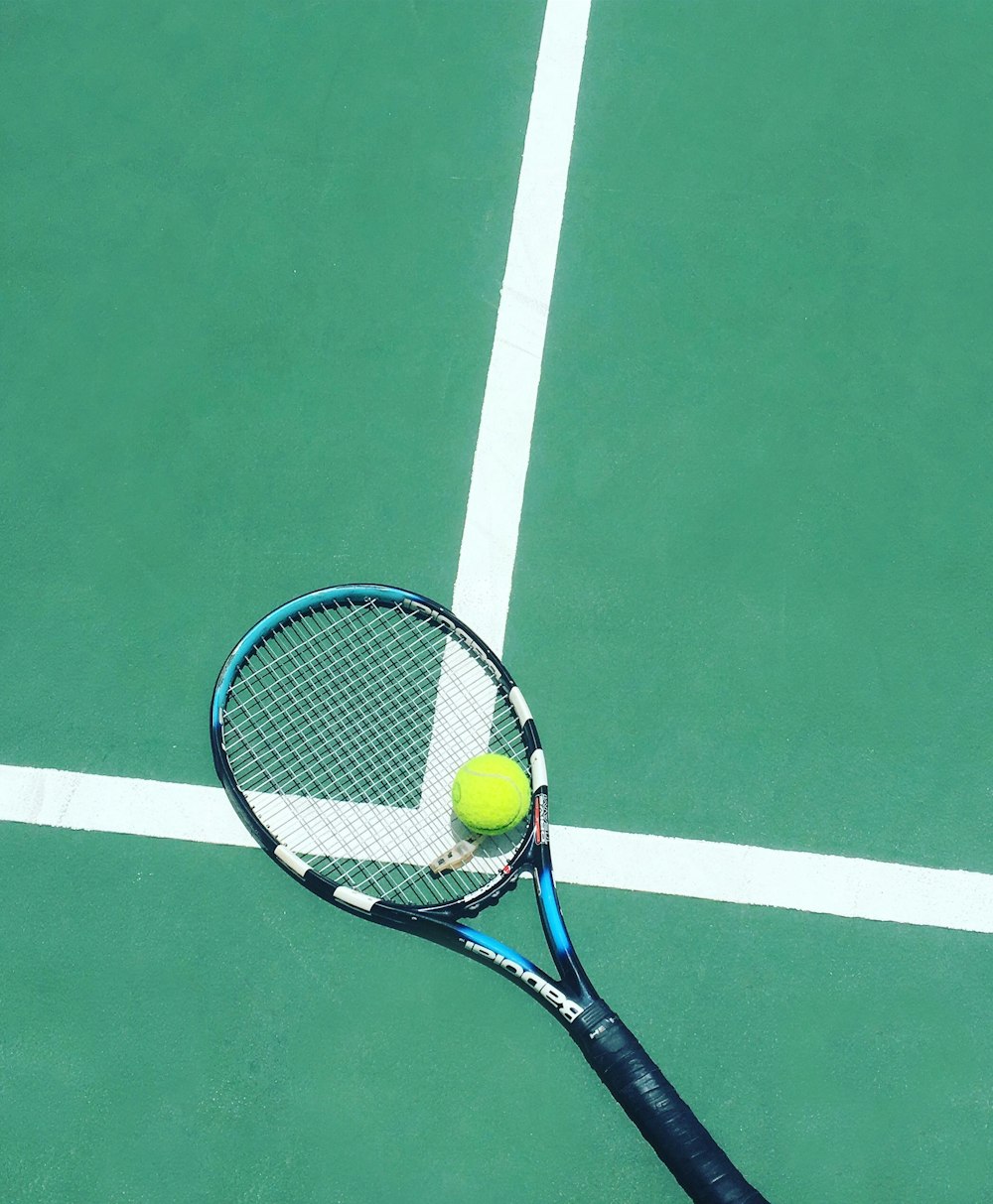 Tennis racket and ball on court